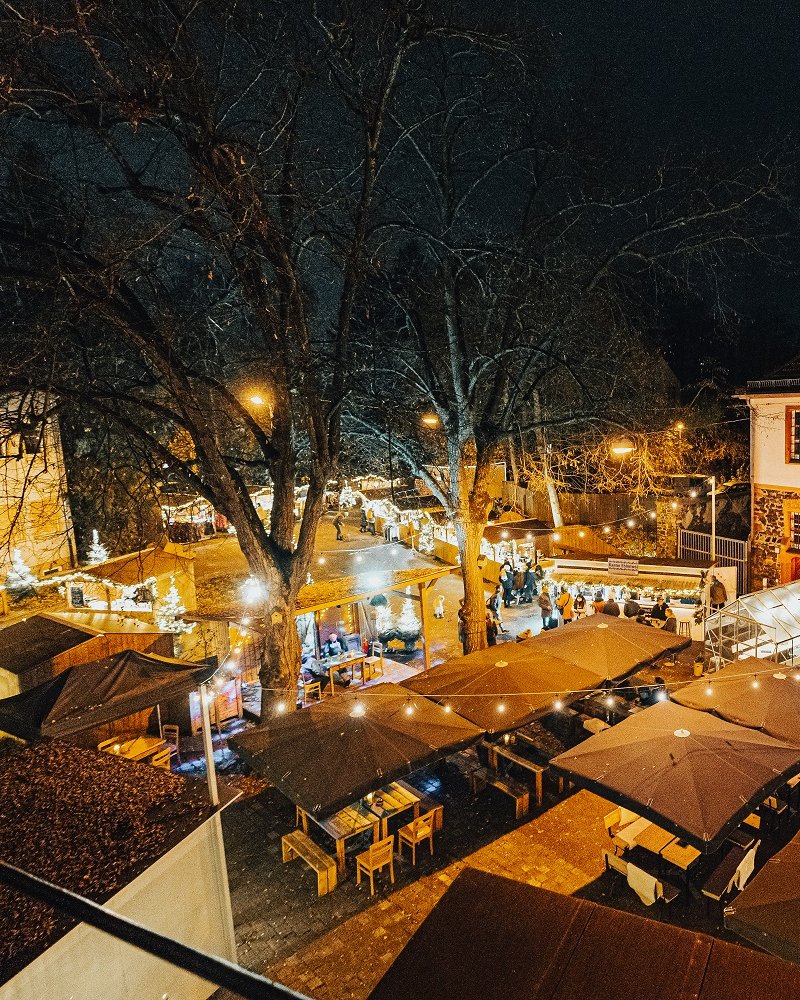 Weihnachtsmarkt mit Lichtern und Markthütten im Fronhof