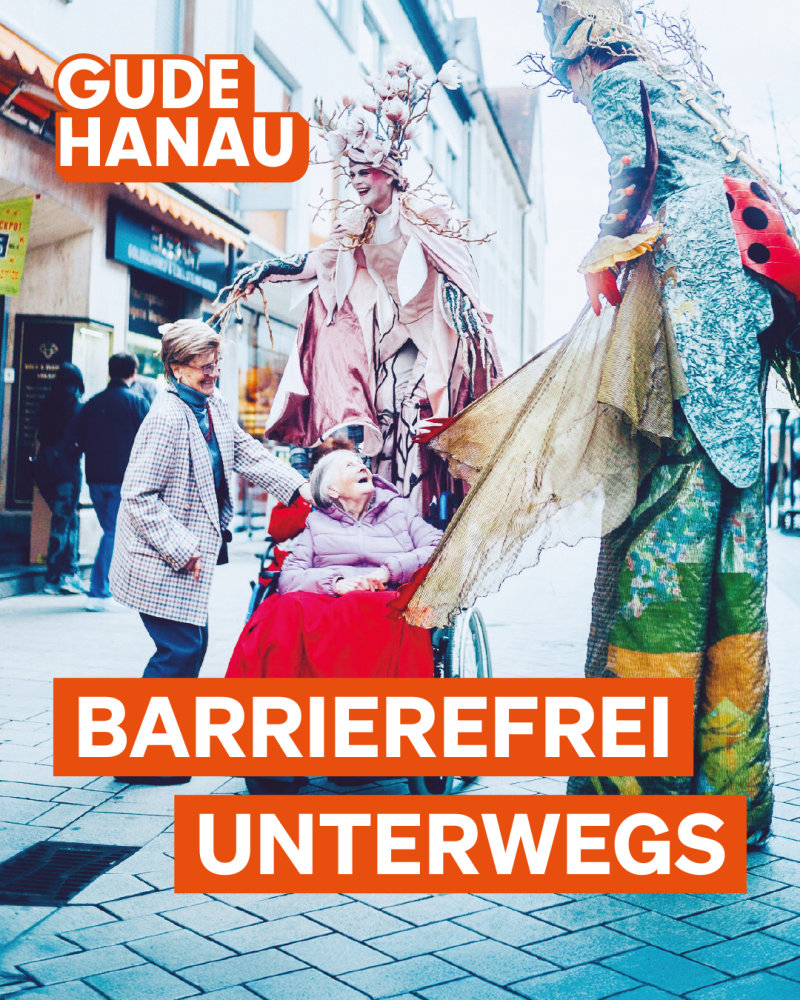 Frau im Rollstuhl und Stelzenläufer auf der Fußgängerzone in Hanau